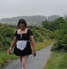 Transvestitenmädchen relative to einer öffentlichen Gasse im Regen